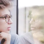 Man looking at himself in window reflection