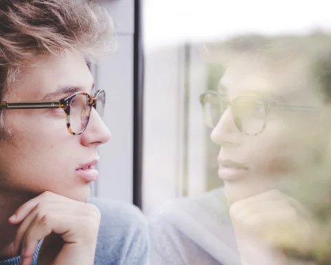 Man looking at himself in window reflection