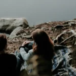 Couple talking by a river bank