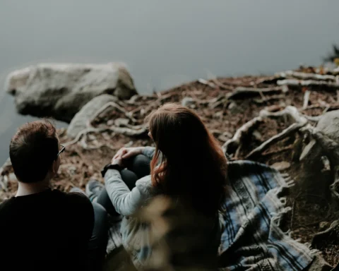 Couple talking by a river bank