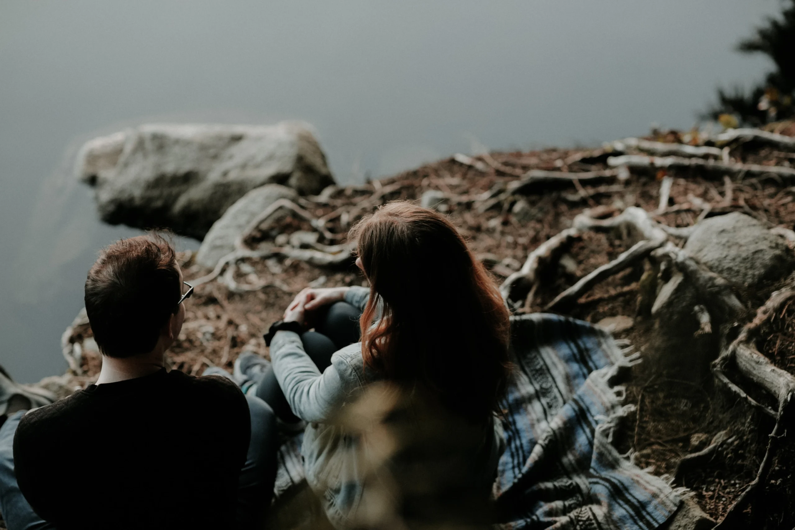 Couple talking by a river bank