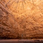 Wall of rock towering over man