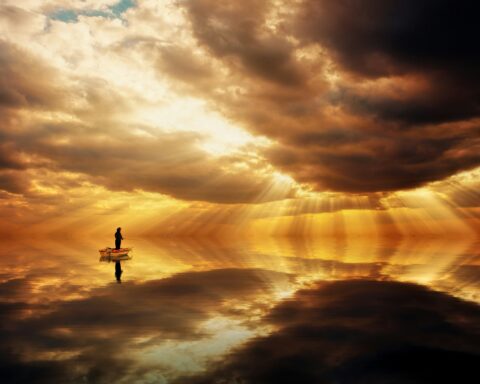 Man fishing on lake in sunrise