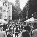 A black and white photo capturing a busy street filled with people in Sopot, Poland during the day.