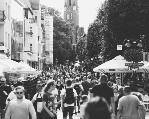 A black and white photo capturing a busy street filled with people in Sopot, Poland during the day.