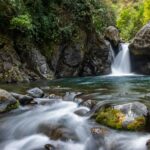 Tranquil waterfall cascading through mossy rocks in a lush forest setting. Perfect for nature lovers.
