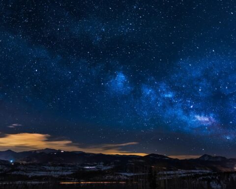 A breathtaking view of the Milky Way galaxy illuminating the night sky over mountains.