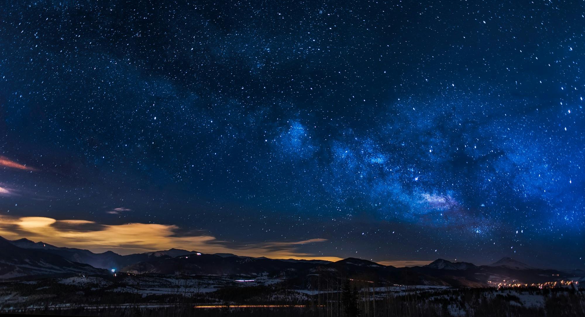 A breathtaking view of the Milky Way galaxy illuminating the night sky over mountains.