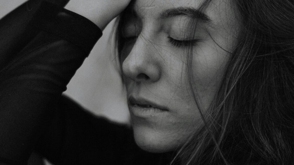 Close-up monochrome portrait of a woman with eyes closed, exuding peace and tranquility.