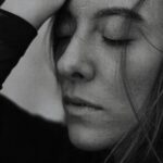 Close-up monochrome portrait of a woman with eyes closed, exuding peace and tranquility.