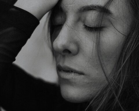 Close-up monochrome portrait of a woman with eyes closed, exuding peace and tranquility.